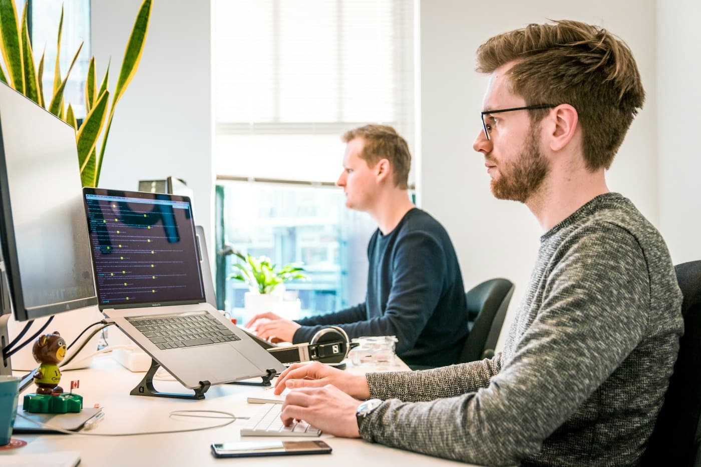 Two engineers reviewing code together at a monitor